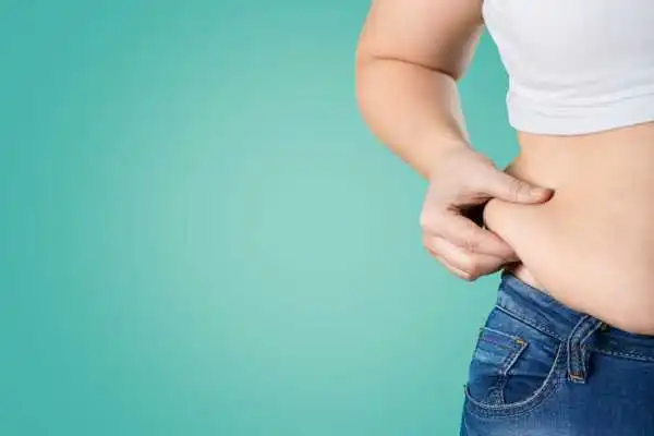 Image of woman pinching her love handles to show weight gain Chesterfield